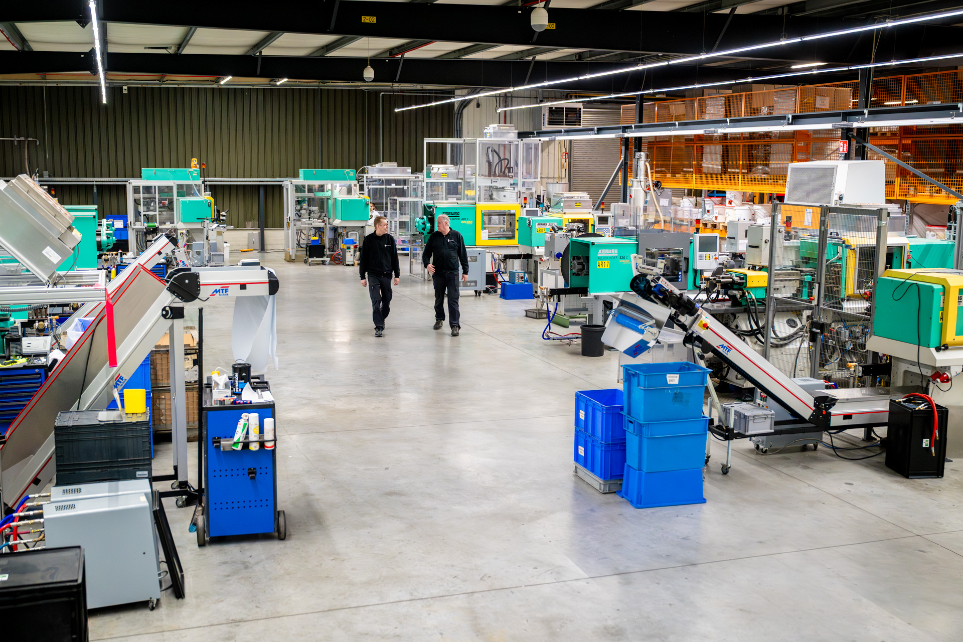 Moderne fabriekshal met machines en werkers.